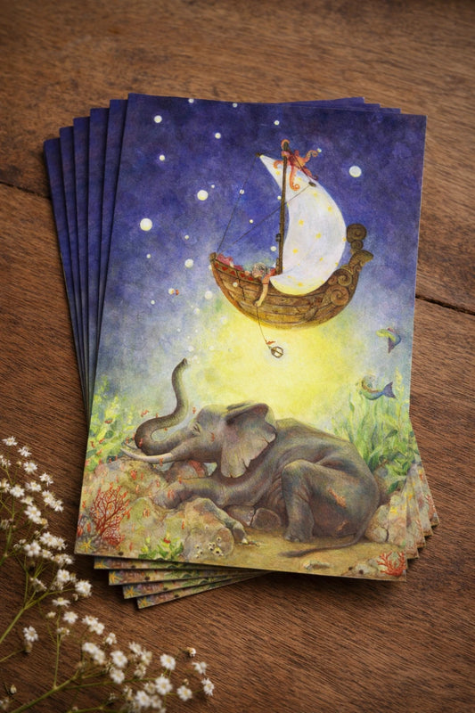 Ansichtkaart met een print van een handgemaakte illustratie door illustrator Amber Moonen. De illustratie toont een bootje dat door een dromerige nacht vaart, met een maan als zeil boven een slapende olifant. Een magische en verhalende ansichtkaart vol fantasie en zachtheid, die uitnodigt tot wegdromen en verwondering.